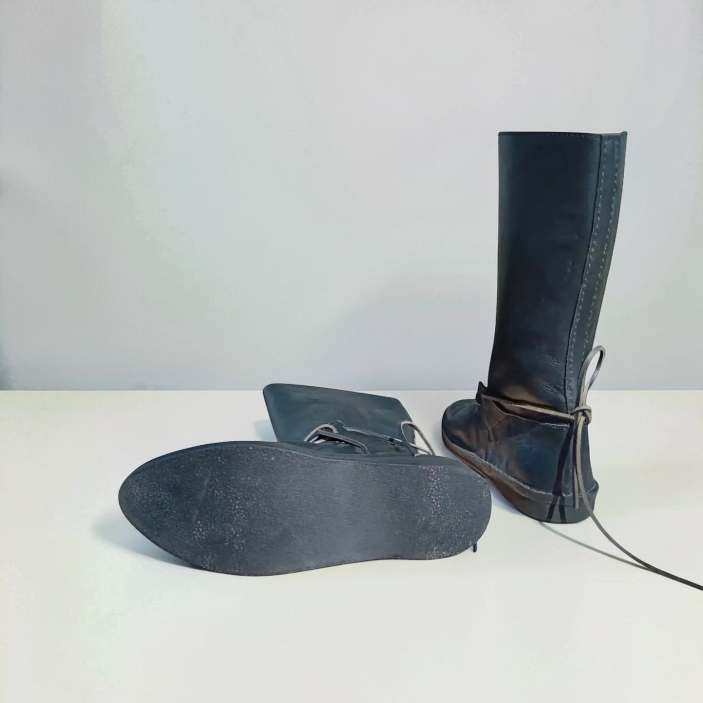 Black handmade medieval leather boots with wrap laces and textured sole, crafted from full-grain leather for LARP and reenactment.