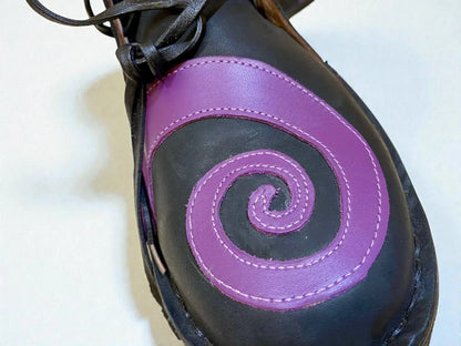 Black medieval leather boot with purple spiral design, handmade full-grain leather, detailed stitching and wrap laces