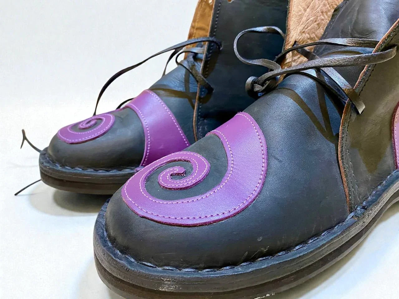 Handmade medieval leather boots with purple spiral design, full-grain leather, and wrap laces for LARP or Renaissance faire.