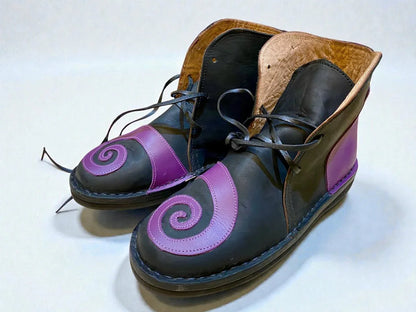 Handmade medieval leather boots with purple spiral design, black wrap laces, and full-grain leather texture for LARP or Renaissance faire.