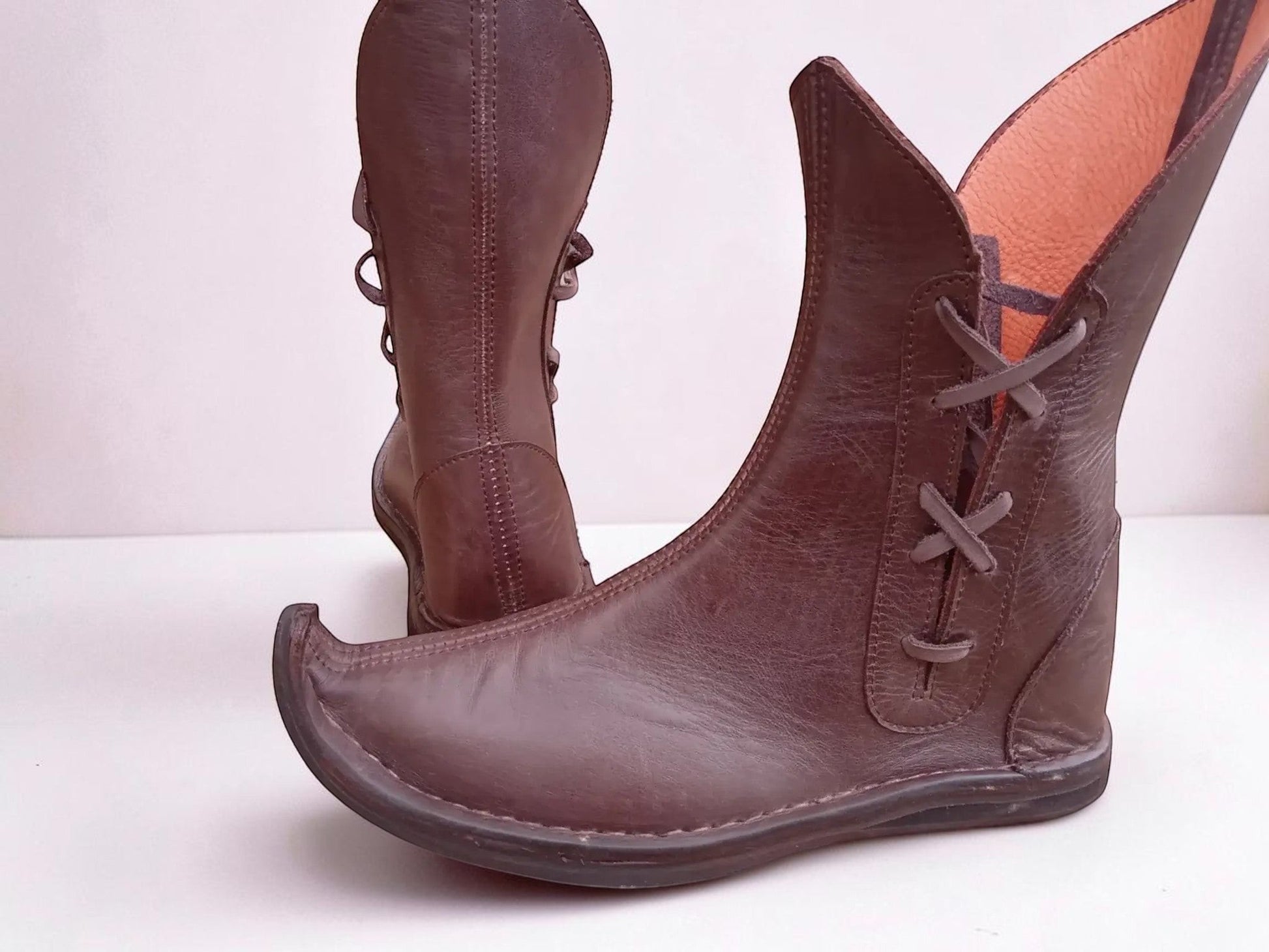 Handmade brown medieval leather boots with wrap laces, visible stitching, and full-grain texture, ideal for LARP or Renaissance faire.