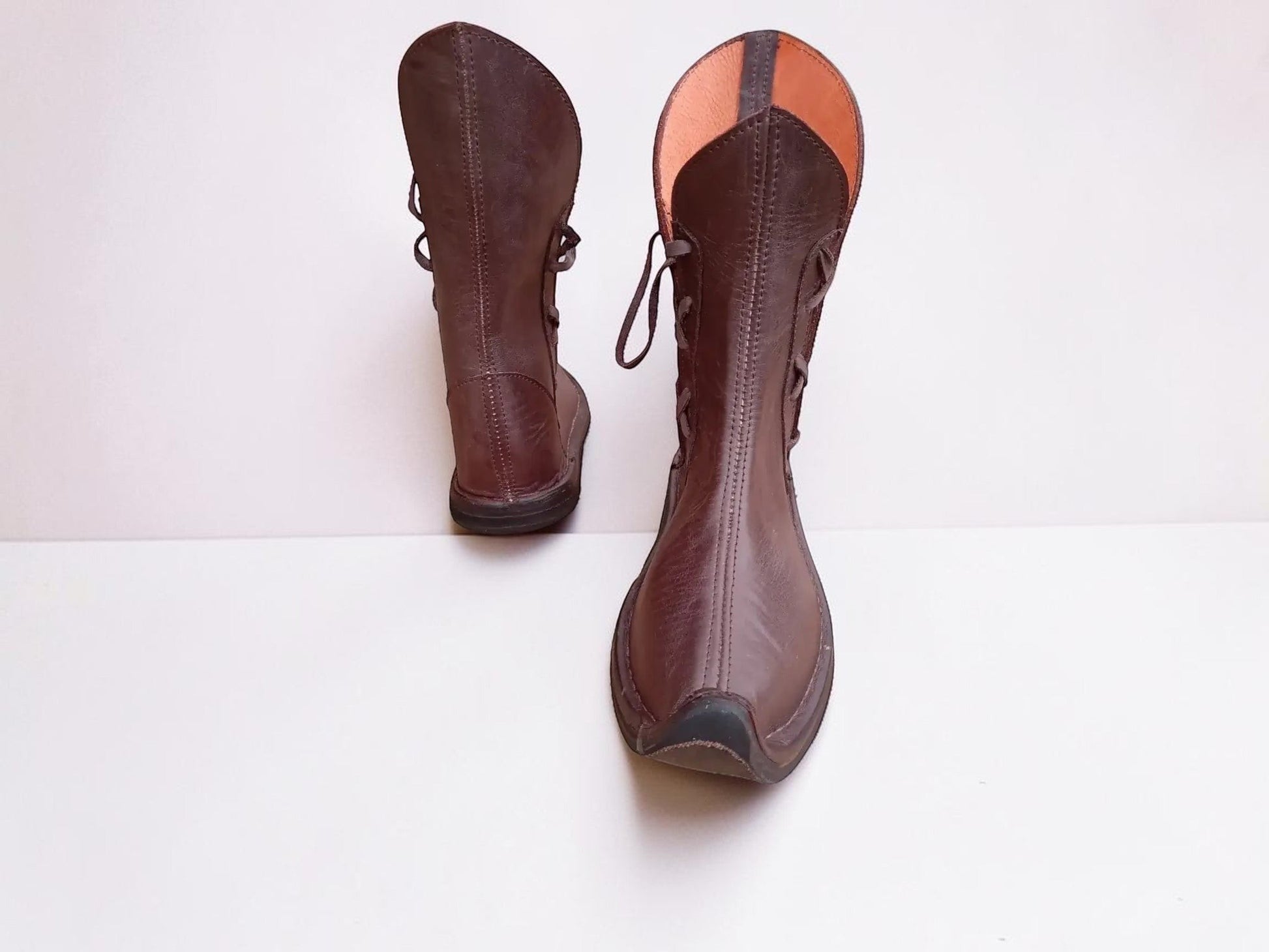 Handmade medieval leather boots with wrap laces, visible stitching, and full-grain leather texture, ideal for LARP or SCA reenactment.