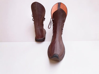 Handmade medieval leather boots with wrap laces, visible stitching, and full-grain leather texture, ideal for LARP or SCA reenactment.
