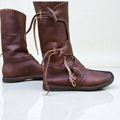 Handmade medieval leather boots with wrap laces and visible stitching, crafted from full-grain leather for LARP or reenactment.