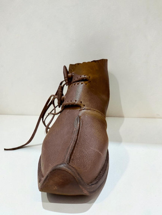 Handmade medieval leather boot with wrap laces and visible stitching, crafted from full-grain leather for LARP or SCA reenactment.