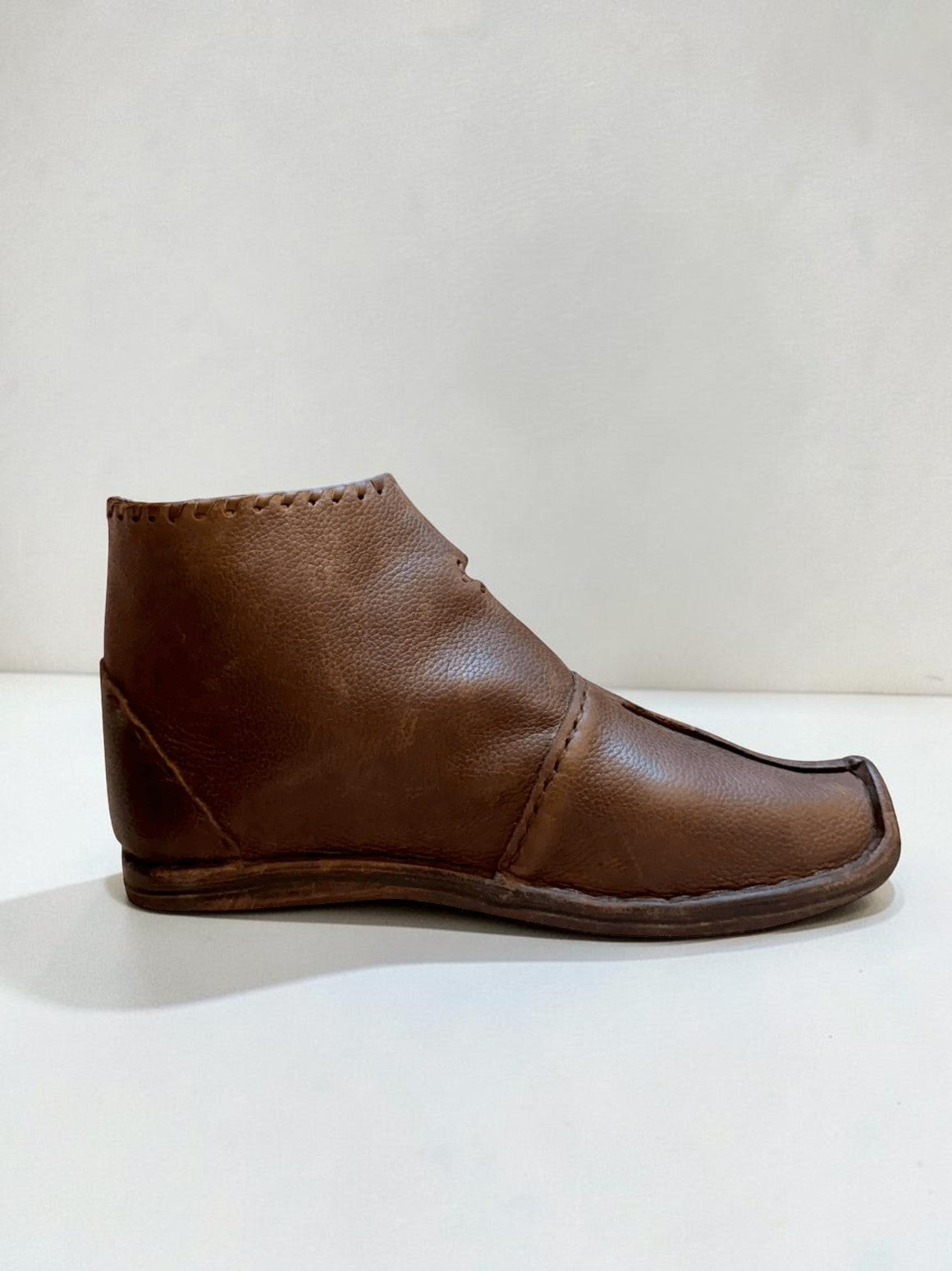 Handmade brown medieval leather boot with visible stitching and full-grain texture, ideal for LARP or SCA reenactment.