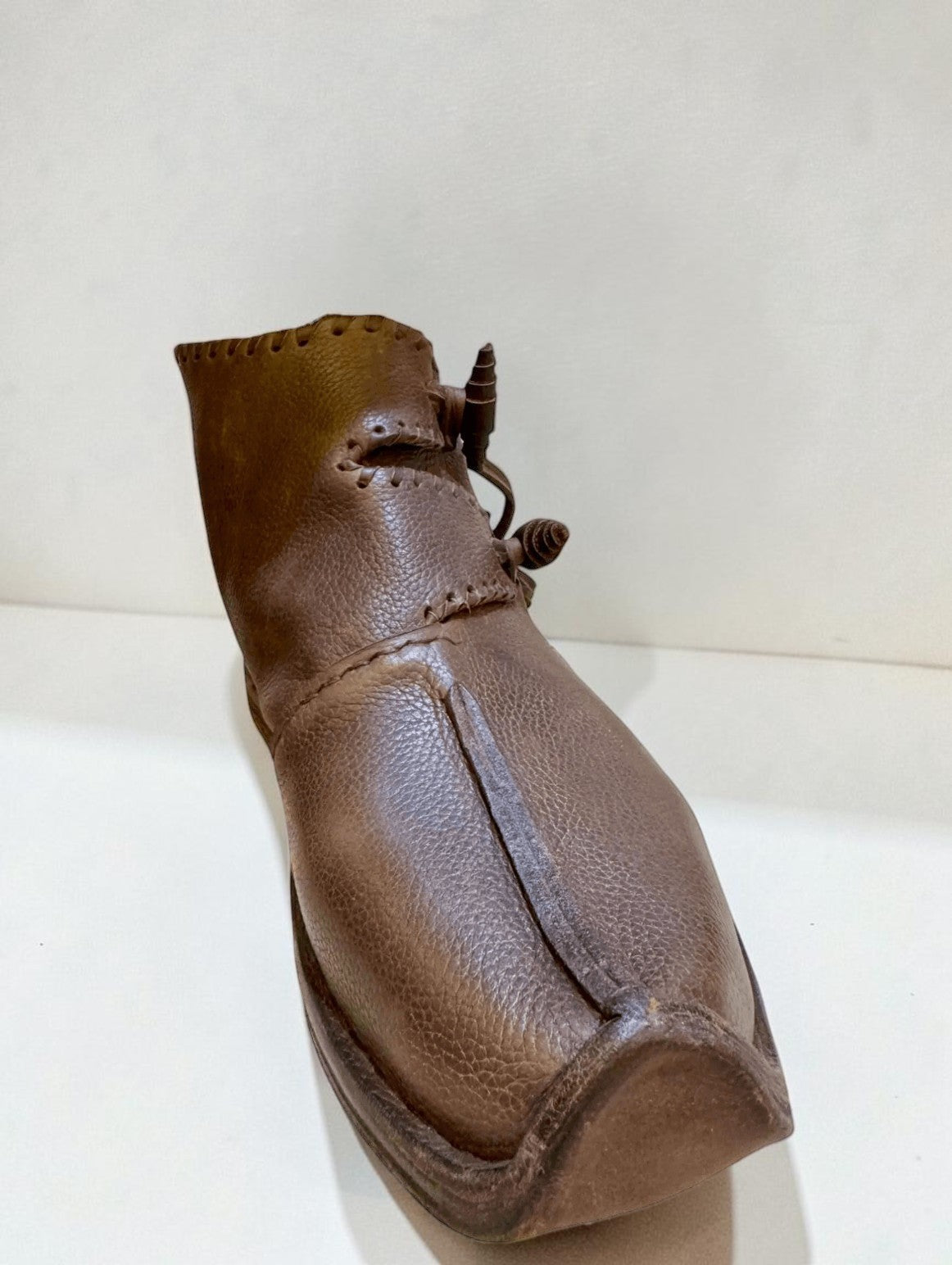 Handmade brown medieval leather boot with wrap laces and visible stitching, crafted from full-grain leather for LARP or SCA.