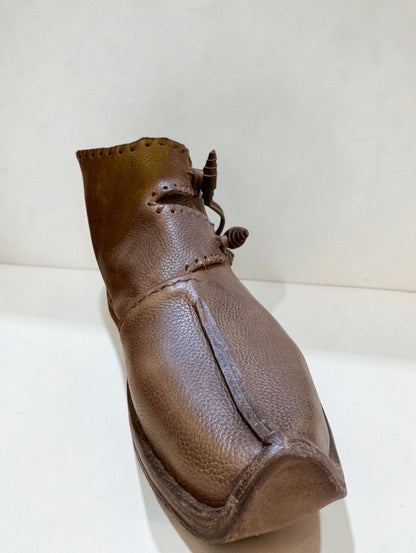 Handmade brown medieval leather boot with wrap laces and visible stitching, crafted from full-grain leather for LARP or SCA.