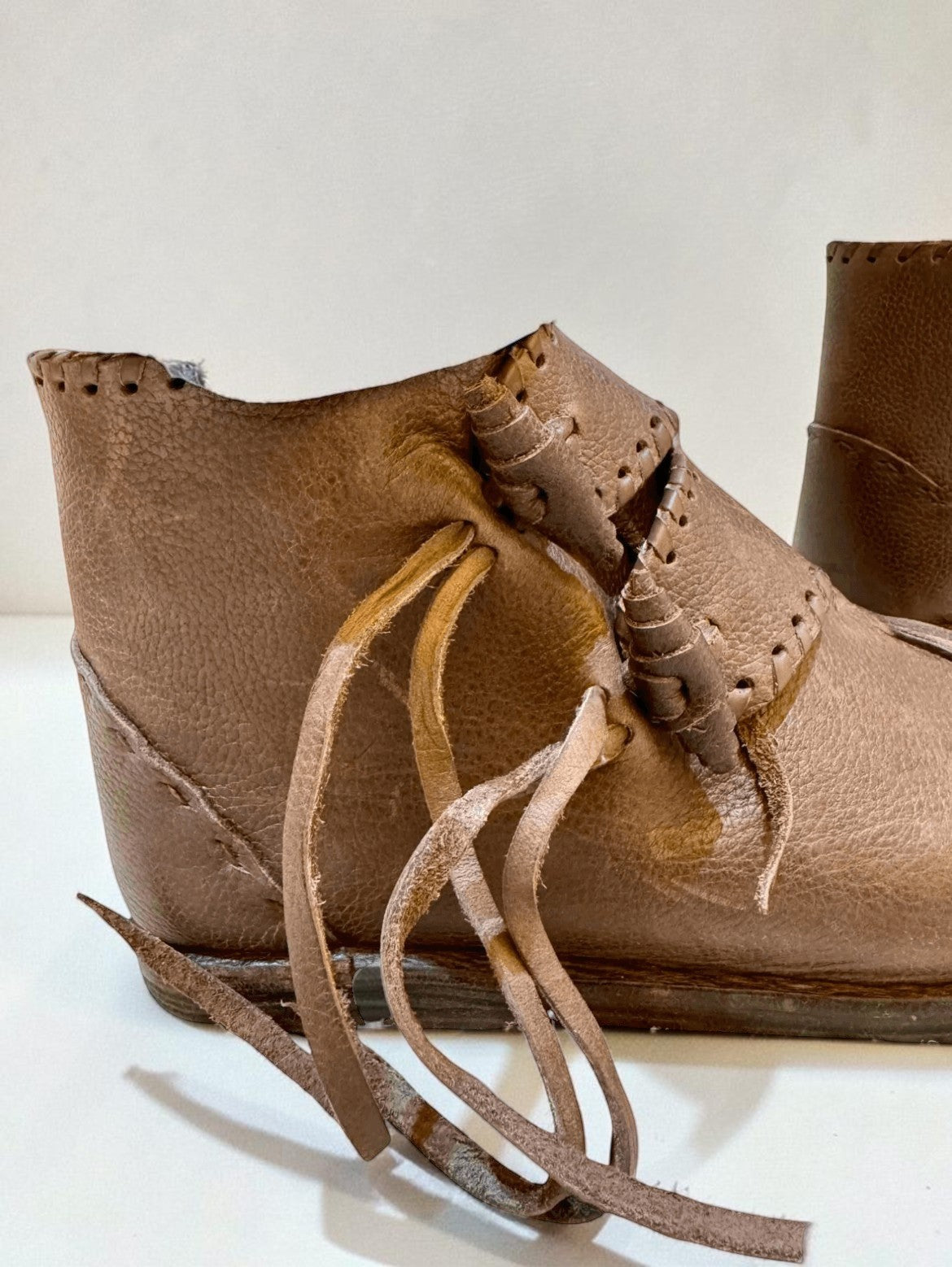 Handmade medieval leather boot with wrap laces and visible stitching, crafted from full-grain leather for LARP or SCA reenactment.