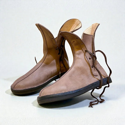 Handmade medieval leather boots with wrap laces, full-grain texture, and sturdy soles for LARP or SCA reenactment.