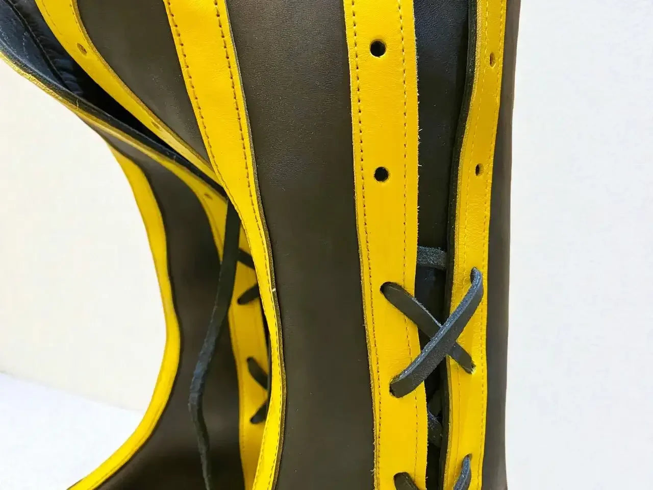 Black and yellow handmade medieval leather boots with wrap laces and visible stitching, crafted from full-grain leather.