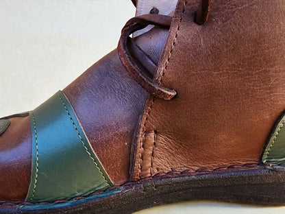 Handmade medieval leather boot with rich brown and green full-grain leather, detailed stitching, and wrap laces for LARP or SCA.