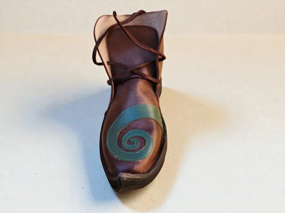 Handmade medieval leather boot with green spiral design, wrap laces, and full-grain texture for LARP or Renaissance faire.