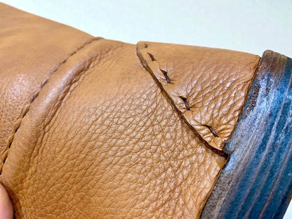 Close-up of handmade medieval leather boot with full-grain texture and sturdy stitching detail