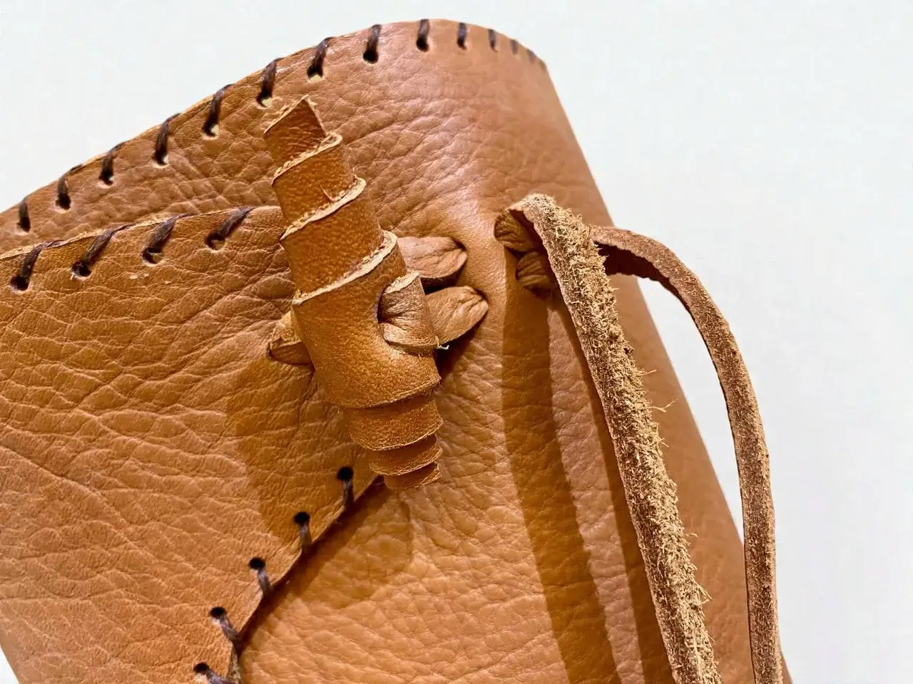 Close-up of handmade medieval leather boot with full-grain texture, wrap laces, and detailed stitching for LARP or SCA reenactment.