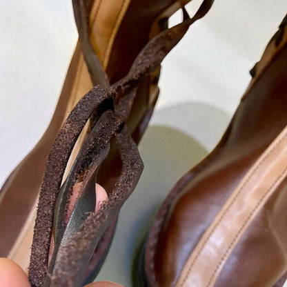 Close-up of handmade medieval leather boots showing full-grain texture, wrap laces, and sturdy stitching for LARP or SCA use.