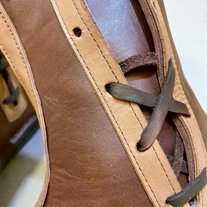 Close-up of handmade medieval leather boots with full-grain texture, wrap laces, and detailed stitching for LARP or SCA reenactment.